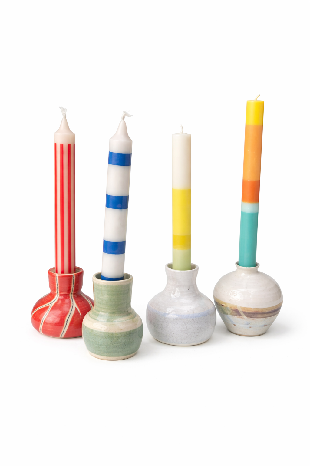 Quatre bougies dans des bougeoirs en céramique décorative